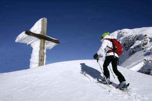 Ski de randonnee devant une croix de pelerinage sur la pointe de la Fogliettaz a Sainte Foy, Savoie, France, MR